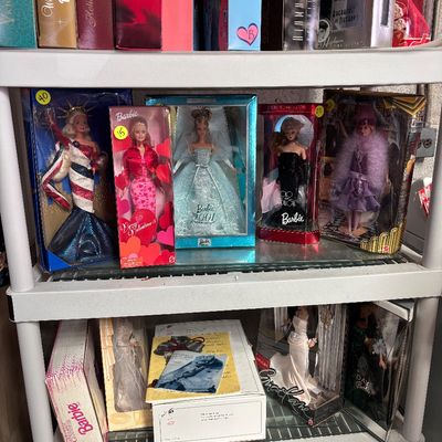 Sale Photo Thumbnail #105: Collection of vintage special edition boxed Barbie dolls displayed on plastic shelving unit, including Liberty Barbie, Barbie 2001, and Very Valentine Barbie.