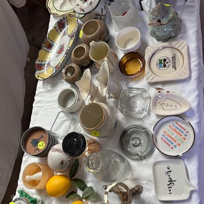 Sale Photo Thumbnail #60: A tabletop array of assorted vintage housewares, ceramics, ashtrays, glass decanters, and decorative trinkets.