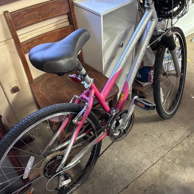 Sale Photo Thumbnail #61: Diamondback Sereno hybrid bicycle in silver and pink with front basket and Shimano components, showing some chain rust.