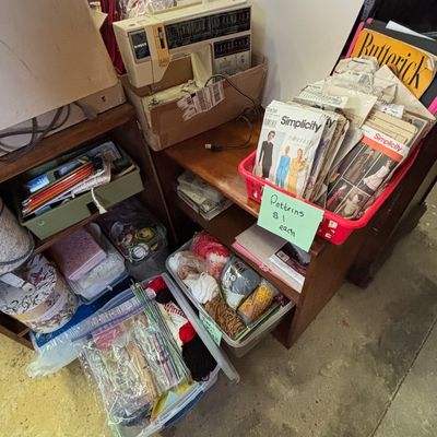 Sale Photo Thumbnail #18: Vintage Singer sewing machine displayed on a wooden stand alongside baskets of sewing patterns, yarn, and crafting supplies.