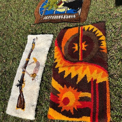 Sale Photo Thumbnail #10: Collection of three vintage handmade latch-hook or punch-needle rugs, including a bold mid-century modern sunburst motif, a window scene with a black cat, and a long runner featuring a rifle motif.
