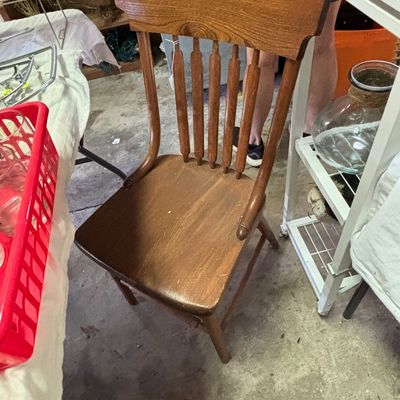 Sale Photo Thumbnail #54: Vintage oak dining chair featuring turned spindle backrests and a contoured wooden seat.