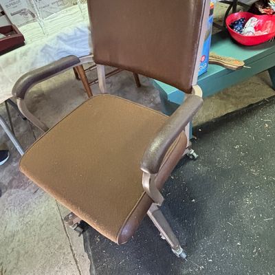 Sale Photo Thumbnail #53: Vintage mid-century office swivel chair with brown vinyl upholstery and a caster base.