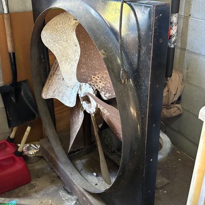 Sale Photo Thumbnail #14: Large vintage industrial square metal exhaust fan with rusted metal blades and attached power cord.