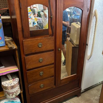 Sale Photo Thumbnail #110: Vintage wooden armoire cabinet featuring a full-length mirrored door, four stacked drawers with brass pull handles, and an upper mirrored compartment door.