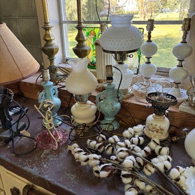 Sale Photo Thumbnail #77: Collection of vintage table lamps, including brass, milk glass hobnail, and hand-painted ceramic styles, displayed with a cluster of decorative cotton bolls.