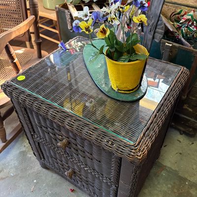 Sale Photo Thumbnail #33: Dark brown woven wicker side table with two drawers and a glass top surface.