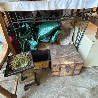 Sale Photo Thumbnail #28: Rustic wooden chest with metal hardware, displayed alongside decorative planters, garden shoes, and green storage bags under a wrought iron cart.