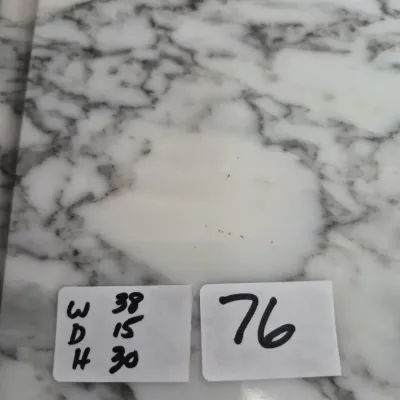 Sale Photo Thumbnail #120: White marble tabletop featuring grey veining, shown with handwritten lot tag number 76 and dimensions.