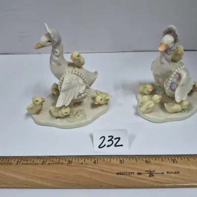 Sale Photo Thumbnail #398: Pair of vintage porcelain mother goose and gosling figurines wearing bonnets and carrying baskets, shown in good condition with minor surface wear.
