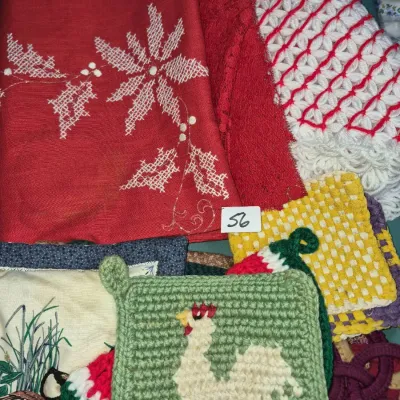 Sale Photo Thumbnail #89: Assorted vintage linens and handmade potholders, including embroidered red Christmas linens and a crocheted green potholder featuring a rooster design.