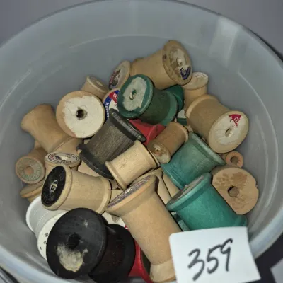 Sale Photo Thumbnail #622: Collection of vintage wooden thread spools filled inside a plastic bucket.