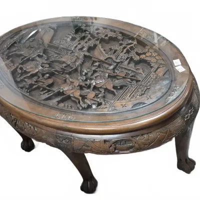 Sale Photo Thumbnail #193: Intricately hand-carved Chinese wood coffee table featuring a detailed battle scene under a fitted glass top, supported by claw feet.