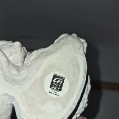 Sale Photo Thumbnail #819: Underside of a white cast sculpture featuring a 1991 Cast Art Industries manufacturer sticker, made in Mexico.