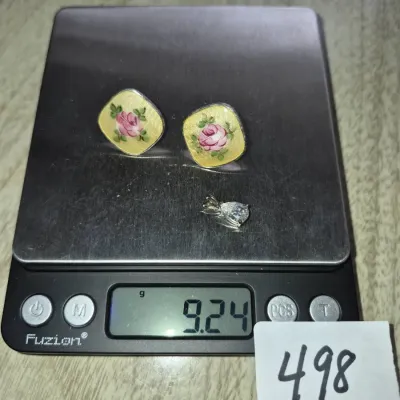 Sale Photo Thumbnail #857: Pair of yellow enamel floral clip-on earrings alongside a small clear teardrop pendant, sitting on a digital scale showing a total weight of 9.24 grams.
