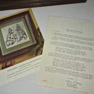 Sale Photo Thumbnail #598: The Franklin Mint promotional brochure and accompanying letter for "The North American Grizzly Bear" silver wall sculpture by Donald Richard Miller, dated 1977.