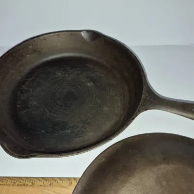 Sale Photo Thumbnail #625: Vintage cast iron skillet marked with a number 8 on the handle, featuring double pour spouts and an aged patina.