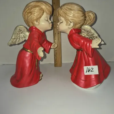 Sale Photo Thumbnail #282: Pair of vintage resin kissing angel figurines in red robes with gold trim, measuring approximately 11 inches tall.