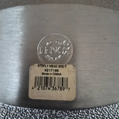Sale Photo Thumbnail #659: Underside detail of a Lenox Butterfly Meadow metal bread tray showing the stamped logo and original product barcode label.