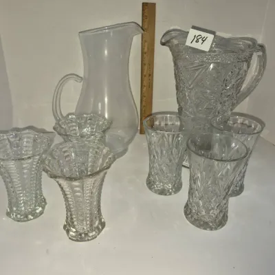 Sale Photo Thumbnail #316: Collection of clear glass items including two pitchers and six matching sets of patterned glassware vases.