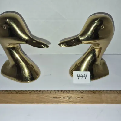 Sale Photo Thumbnail #769: Pair of vintage brass duck head bookends displayed next to a wooden ruler for scale.