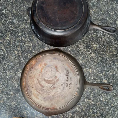 Sale Photo Thumbnail #653: Two vintage cast iron pans shown upside down, including a Birmingham Stove & Range No. 8 skillet measuring 10 1/4 inches.