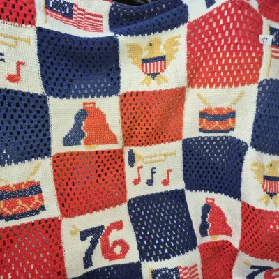 Sale Photo Thumbnail #77: Hand-crocheted Bicentennial-themed afghan blanket featuring patriotic symbols including American flags, bald eagles, drums, horns, and '76 motifs in red, white, and blue, circa 1976.