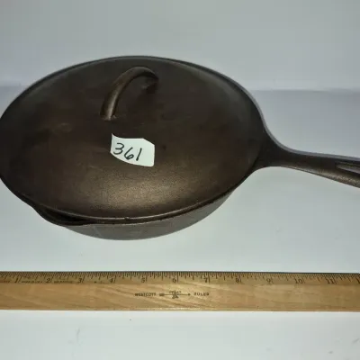 Sale Photo Thumbnail #624: Vintage cast iron skillet with matching lid, shown with a 12-inch wooden ruler for scale.