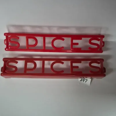 Sale Photo Thumbnail #606: Pair of vintage red molded plastic wall-mounted spice racks with cut-out lettering.