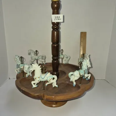 Sale Photo Thumbnail #296: Vintage carousel-style wooden tray featuring small ceramic horse figures mounted around a turned center spindle.