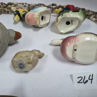 Sale Photo Thumbnail #450: Collection of vintage bird and animal figurines, including several stamped 'Japan' and 'Hecho en Mexico', shown alongside a shell necklace.