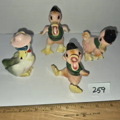 Sale Photo Thumbnail #442: Set of four vintage mid-century ceramic duck figurines featuring playful anthropomorphic poses and painted details.