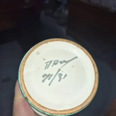 Sale Photo Thumbnail #41: Underside of a ceramic vessel showing a hand-painted artist signature and the numbers '71/31'.