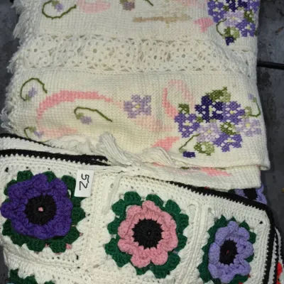 Sale Photo Thumbnail #82: Handmade crochet and cross-stitch afghan blankets featuring floral patterns in shades of purple, pink, and green.