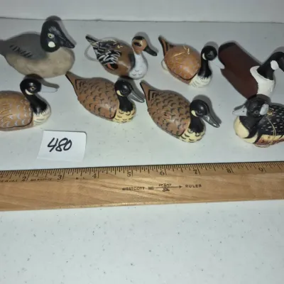 Sale Photo Thumbnail #825: Collection of eight miniature hand-painted duck and waterfowl figurines, including wood and resin decoys and ornaments.