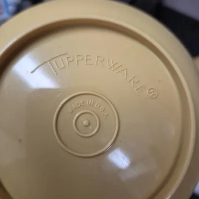 Sale Photo Thumbnail #674: Vintage tan Tupperware container base showing the embossed Tupperware logo and 'Made in U.S.A.' mark.