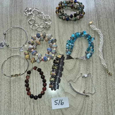 Sale Photo Thumbnail #889: Collection of nine fashion bracelets, including beaded, silver-tone chain, rolled paper bead, faux pearl, and religious image panel designs.