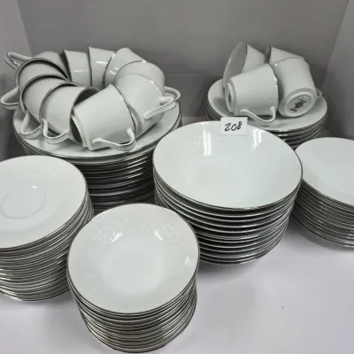 Sale Photo Thumbnail #356: Large service of vintage white porcelain dinnerware featuring silver rims and a subtle raised floral pattern, including dinner plates, bowls, teacups, and saucers.