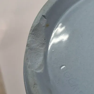 Sale Photo Thumbnail #362: Close-up detail showing a noticeable chip along the unglazed base rim of a light blue ceramic piece.