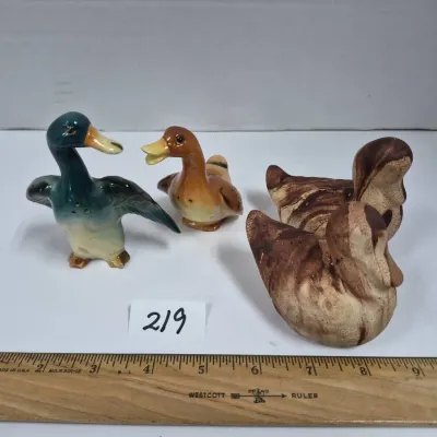 Sale Photo Thumbnail #376: Collection of four vintage duck figurines, including a pair of ceramic salt and pepper shakers and two textured brown ceramic ducks.