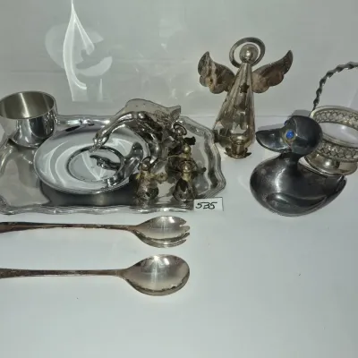 Sale Photo Thumbnail #924: Collection of silver-tone and pewter decor items, including a duck figurine with blue eyes, an angel candle holder, serving spoons, a small tray, and miniature novelty pieces.