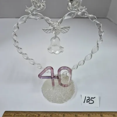 Sale Photo Thumbnail #225: Hand-blown spun glass 40th anniversary cake topper featuring a heart frame with lovebirds, a dangling bell, and lavender numerals on a textured base.
