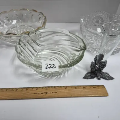 Sale Photo Thumbnail #383: Collection of decorative glassware including three pressed and molded glass bowls, one with gold rim detailing, alongside a small glass trumpet vase with a pewter-tone floral base.