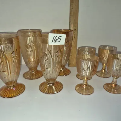 Sale Photo Thumbnail #286: Set of eight marigold carnival glass stemmed goblets featuring a floral and ribbed pattern.