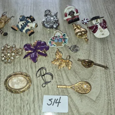 Sale Photo Thumbnail #887: Collection of vintage fashion brooches and pins, featuring holiday snowmen, floral, tennis racket, and initial designs.
