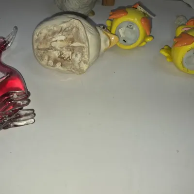 Sale Photo Thumbnail #336: Collection of small bird-themed figurines, including a pink art glass swan and novel yellow chick salt and pepper shakers.