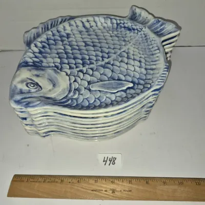 Sale Photo Thumbnail #776: Stack of vintage blue and white ceramic fish-shaped appetizer plates featuring textured scale details.