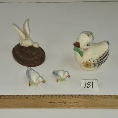 Sale Photo Thumbnail #257: Collection of four vintage bird figurines, including a cast metal bird on an oval base, a ceramic duck salt or pepper shaker, and two miniature porcelain ducklings.