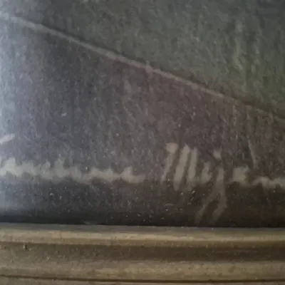 Sale Photo Thumbnail #531: Close-up detail of an artist's signature on a framed painting, written in light-colored cursive script along the bottom edge.
