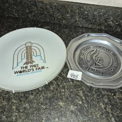 Sale Photo Thumbnail #716: Pair of World's Fair commemorative plates, including a 1982 Knoxville porcelain plate and a 1984 Louisiana World Exposition pewter plate.